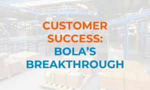Warehouse background with text overlay reading “Customer Success: Bola’s Breakthrough” in bold orange and blue lettering.